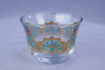 Single clear glass traditional Arabic coffee cup finjan with blue and 22K gold geometric pattern design