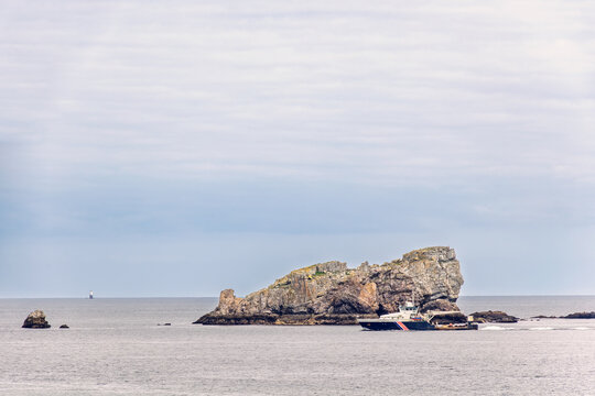 Seascape view with a ship on the sea in a rocky coastline - Powered by Adobe