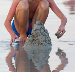 A boy is digging in the sand at the beach