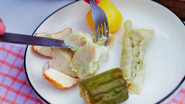 Traditional Indonesian siomay being sliced on a plate, showcasing delicious local street food and culinary culture.