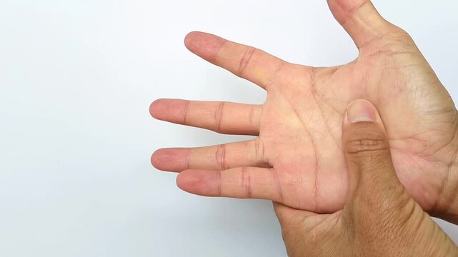 A close-up of a man's hands performing therapeutic massage on sore palms and fingers to relieve joint pain and tension after a warm bath. Trigger finger. Massage therapy.