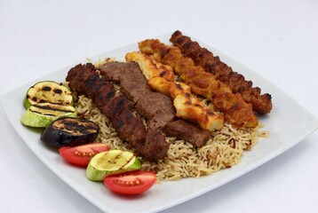 Delicious Grilled Meat Kebabs with Rice and Fresh Vegetables: A Colorful Mediterranean Platter in Traditional Ethnic Food Photography