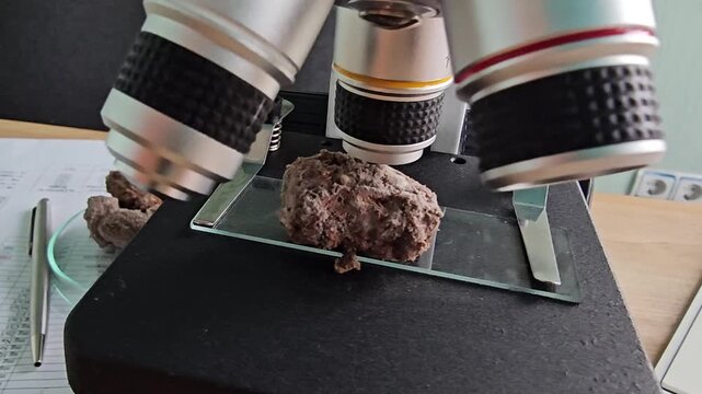 Exploring the details of a rock sample under a microscope in a lab setting