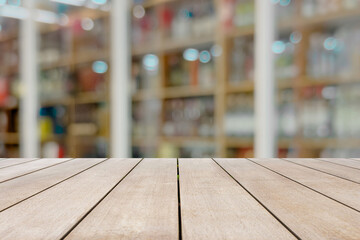 Empty old wooden table in front of blurred background in the cozy and modern living room with bookshelves and natural Llght in contemporary interior design.