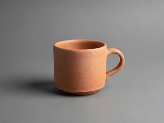 Minimalistic clay mug on a gray backdrop for pottery concept imagery