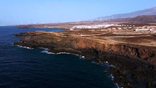 Volcanic coast at dawn with Abades village and windmills, serenity