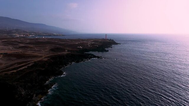 Dawn at Poris lighthouse with windmills on Tenerife coast, tranquil vibe