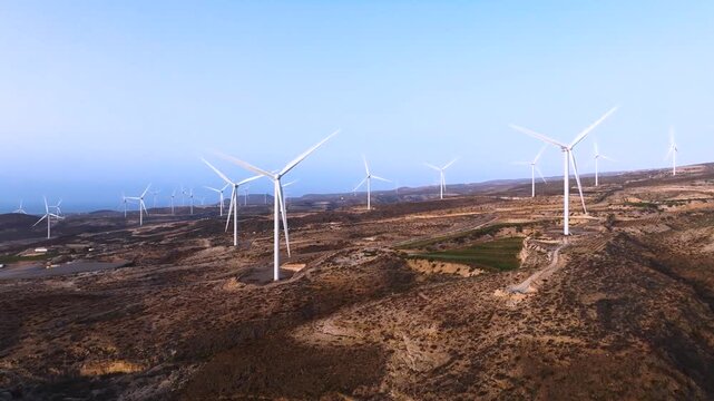 Wind turbines spin in Arico, Tenerife windmill field, clear sky, outdoors
