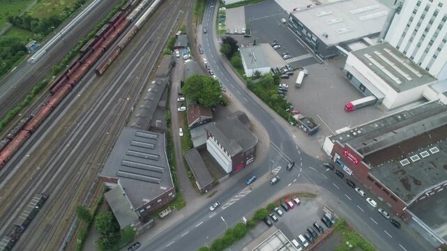 Top down spinning drone shows railway lines, roads and urban industry in Germany