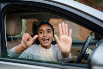 Excited Young Woman Waving and Smiling from Car Window