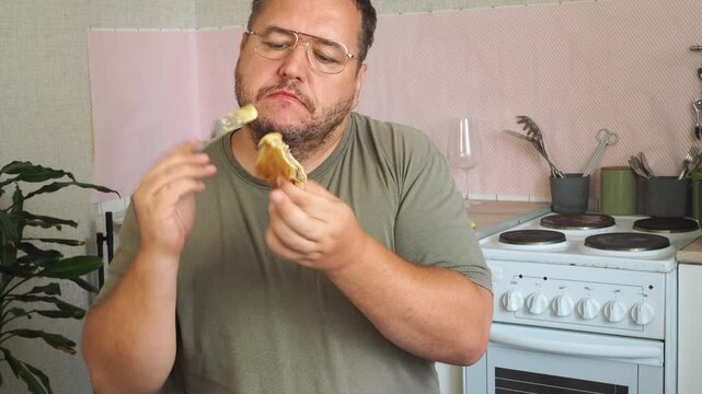 A man eats a cheburek fried in oil.