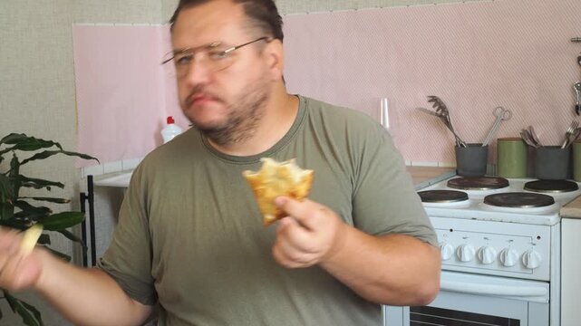 A man eats a cheburek fried in oil.