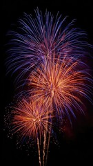 Fototapeta premium Fireworks exploding in the night sky with blue and orange streaks. Concept Night Sky Fireworks, Blue and Orange Streaks, Pyrotechnic Lights, Festive Nightscape, Dramatic Sky Contrast