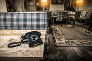 Old retro vintage black telephone on wooden table in old room