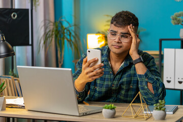 Sad Indian man use smartphone typing browsing, loses becoming surprised sudden lottery online game...
