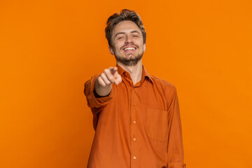 Happy Caucasian young man laughing out loud after hearing ridiculous anecdote, reaction on funny joke, feeling carefree amused. Positive people. Guy isolated on studio orange background. Copy-space