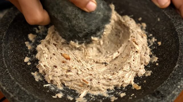 Hands Grinding Bumbu in Mortar for Traditional Indonesian Cuisine Rawon Close-up Shot for Cooking Show Food Blog Recipe