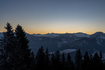 landscape with summits and valleys in blue hour before sunrise above the area of Bregenzerwald, Vorarlberg, Austria, on a clear, frosty morning