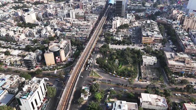 Aerial video of Noida with an elevated metro line running through dense residential blocks and busy roads, highlighting the city&rsquo;s rapid urban growth and transport-driven development. Train entering