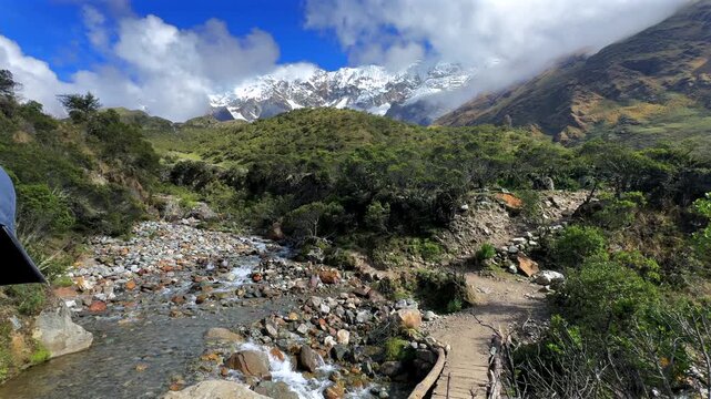 Humantay Laguna Lake Trek trail hiking creek bridge Peru Per&uacute; hiker Peruvian Andes Salkantay glacier high altitude prominent peaks morning blue sky clouds sunny Anta province dry rainy season follow