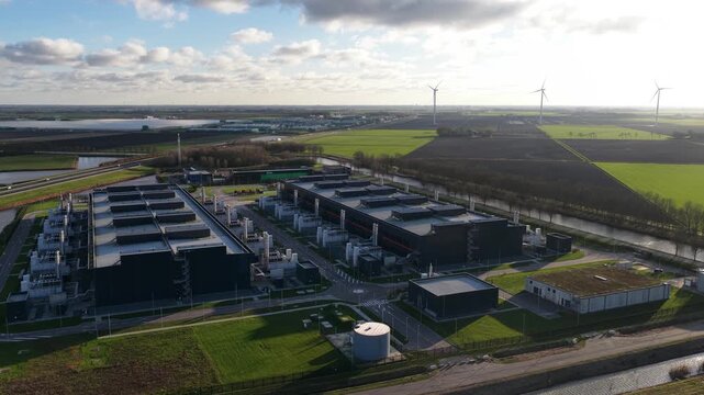 Aerial video of a large scale data center in The Netherlands, redundant computing infrastructure, emergency backup power generators, AI technology supporting big data processing and cloud services.