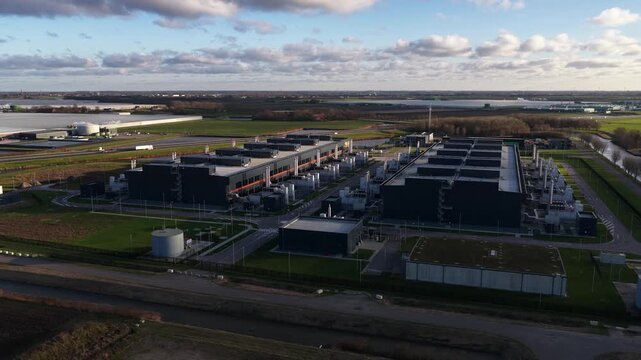 Aerial video of a large scale data center in The Netherlands, redundant computing infrastructure, emergency backup power generators, AI technology supporting big data processing and cloud services.