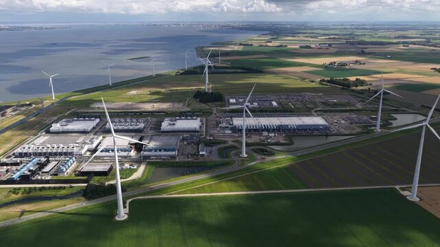 Daytime summer aerial drone video of a large-scale data center in the Eemshaven, The Netherlands, modern computing infrastructure, cloud technology, and high capacity digital processing facilities.