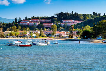 Obraz premium View Sidari Beach with tourists and boats on green holiday island Corfu, Greece. One the most beautiful islands in Ionian Sea.