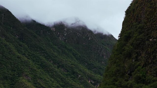 Aguas Calientes Machu Picchu town rainy season cloudy afternoon Peru aerial drone Peruvian Andes Mountains Urabumba river jungle lower highlands Inca trail citadel landscape buildings circle right
