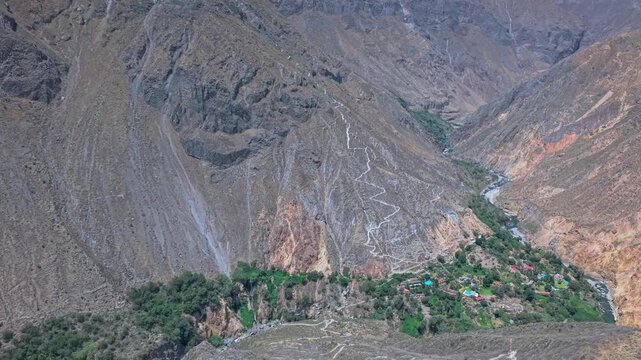 A drone follows the challenging trail from Colca Canyon&rsquo;s oasis floor up to the Cabanaconde rim. This iconic multiday hike route showcases dramatic cliffs, steep terrain, and Peru&rsquo;s epic landscapes.