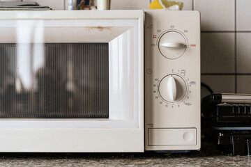 Fototapeta premium Old microwave oven with dials in kitchen setting