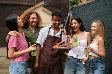 Cheerful diverse friends enjoying grilled food and refreshing drinks at a backyard barbecue party