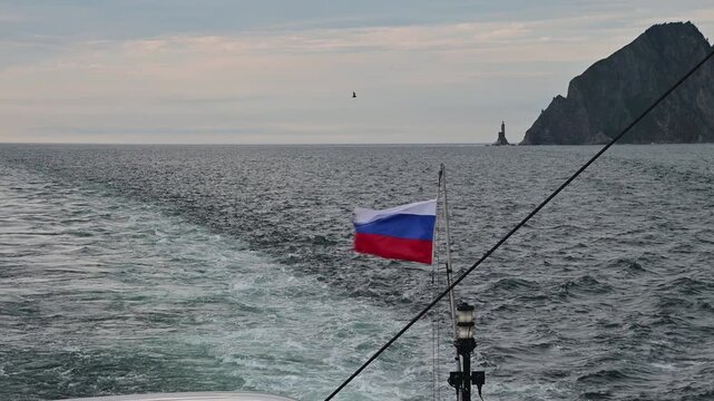Journey through the waves near Aniva Lighthouse in Sakhalin with a Russian flag