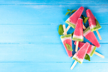 Tasty sweet watermelon ice cream lollies on blue wooden table