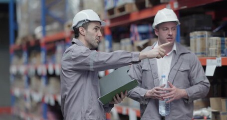 Warehouse workers collaborate on sustainable logistic strategy, review documents, data to implement eco-friendly workflows and reduce carbon footprint of transportation operations in storage facility
 - Powered by Adobe