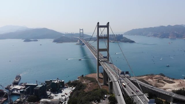 Tsing Ma bridge aerial view from Tsing Yi island side. Large structure span across channel, part of Lantau Link highway, Hong Kong. Rather small traffic on road