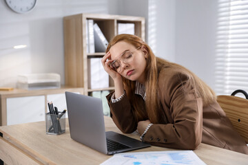 Tired woman snoozing at workplace in office