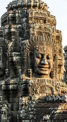 Ancient carved stone faces adorn the towering structure of a historical temple complex