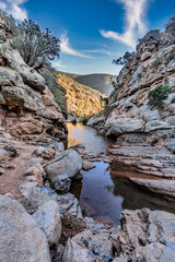 Serene Rocky Canyon Oasis With Pool, Trees, and Mountain Backdrop Under Blue Sky, Tizguan, Agadir, Morocco