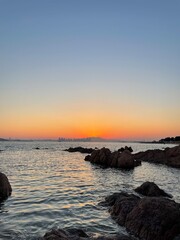 Beautiful sunset over the sea, rocks, coast, yellow and orange colors at Qingtao, China
