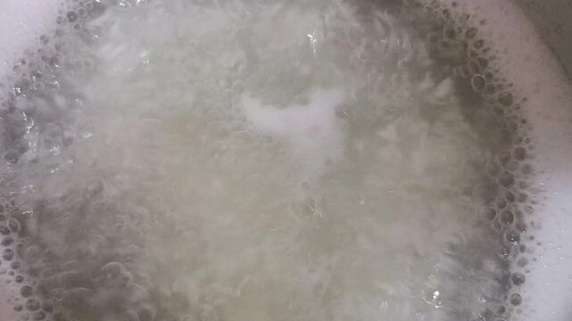 Hot water churning the process of cooking rice using the boiling method