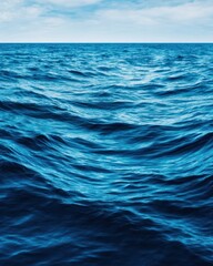 Fototapeta premium Blue Monday Vertical view of deep blue churning ocean water extending towards the horizon under a pale sky