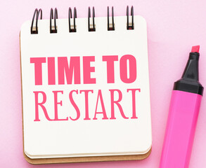 TIME TO RESTART text in notebook on pink background.