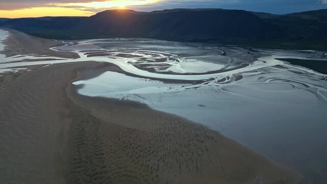 Raudisandur rich coastline twinkles under the radiant Icelandic sun - aerial 4k
