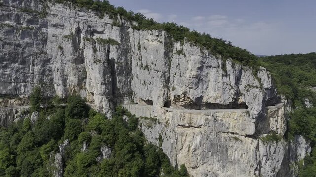 Combe Laval balcony road carved into cliffs in Vercors France. A winding scenic drive with stunning views ideal for motorcycle touring and camper van travel ads.