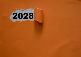 2028 on paper with orange colour cover peeled in concept of new year business plans and new year solutions, New year concept with typographic 2028 on paper
