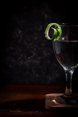 Cocktail glass with lime peel garnish on the rim of the glass