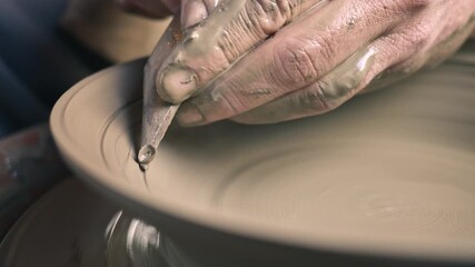 A craftsperson's hands skillfully shape clay on a pottery wheel, showcasing the art of pottery. The focused action highlights creativity and craftsmanship, emphasizing the intricate process.
