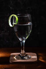 Cocktail glass with lime peel garnish on the rim of the glass