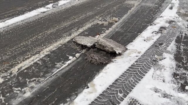 Snow and ice blocks on a road, risk of slipping, snowfall, snow chaos